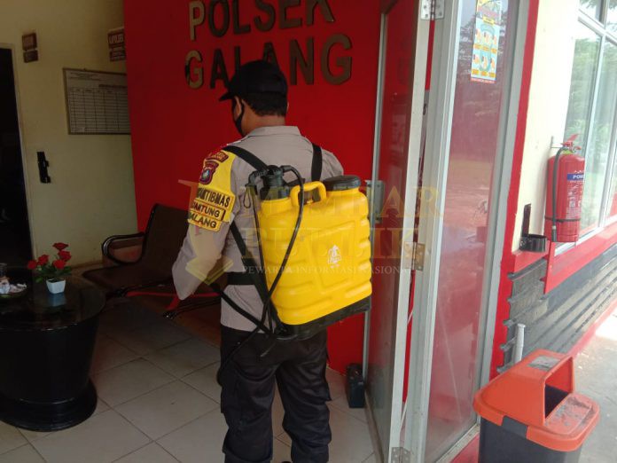 Personil Polsek Galang melakukan penyemprotan disinfektan di Mako Polsek Galang. / ft - istimewa