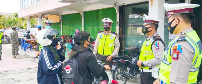 Personil Satlantas Polres Natuna berikan sosialiasi penerapan prokes Covid -19 saat Operasi Yustisi di Jalan Pramuka Ranai, Natuna, Kamis (05/11/2020).