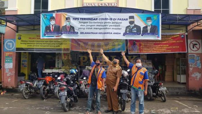 Pjs Wali Kota Batam Syamsul Bahrum mengajak tukang parkir terapkan Prokes cegah covid-19 di Batam. / foto - mcb