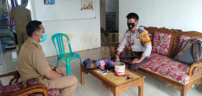 Nadri Bhabinkamtibmas Kecamatan Mesuji saat sosialisasi dengan Kepala Desa Wiralaga Mulya kecamatan Mesuji, Lampung