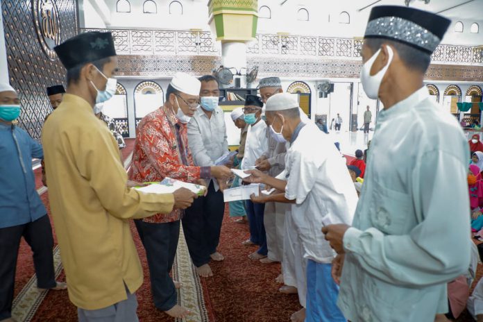 Pj Sekda Asahan Jhon Hardi Nasution (Kiri) secara simbolis memberikan santunan kepada kaum dhuafa dan anak yatim.