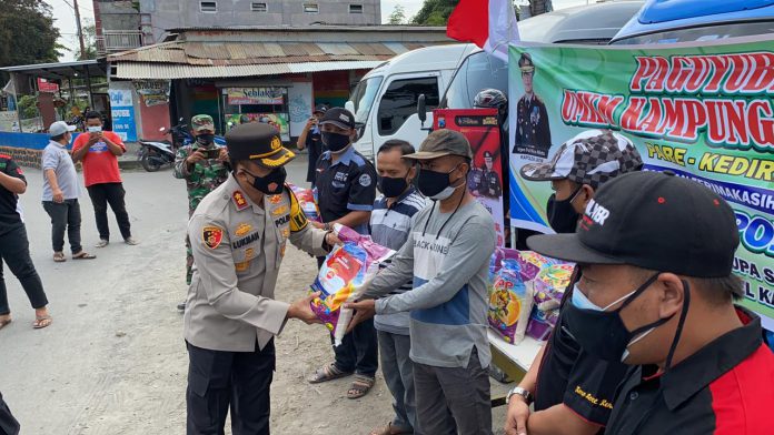 Kapolres Kediri AKBP Lukman Cahyono membagikan ratusan paket sembako kepada paguyuban driver taksi online, pengemudi travel kampung Inggris, dan kelompok Usaha Mikro Kecil Menengah (UMKM) Ganesa di wilayah Kecamatan Pare, Selasa (3/8).