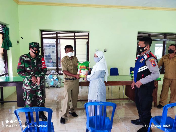 Kades Moch.Maksun bersama TNI/Polri di aula balai Desa Sambirejo saat pembagian bansos, Senin (15/11/2021) Foto: Biro Kediri